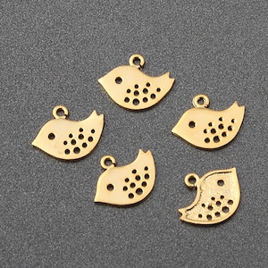 Könnte beinhalten: Fünf goldfarbene Metall-Vogel-Anhänger mit einem gepunkteten Muster. Die Anhänger haben eine Öse oben zum Anbringen an Schmuck oder andere Bastelarbeiten.