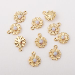 May include: Ten gold-tone flower charms with white opal centers. Each charm has a loop on the top and a jump ring on the bottom.