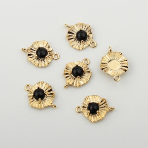 May include: Six gold-toned metal charms with black stone accents. Each charm features a decorative, scalloped design and two jump rings for attaching to jewellery.