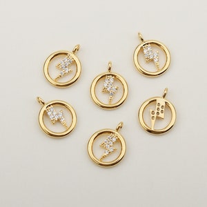 May include: Six gold-tone pendant charms featuring a lightning bolt design with clear rhinestones. The charms are round and have a smooth, polished finish.