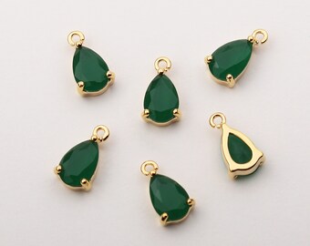 May include: Six gold-tone teardrop-shaped pendants with green glass stones. The pendants have a loop at the top for attaching to a chain or cord.