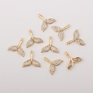 Peut inclure: Dix breloques en forme de queue de sirène dorées avec des accents de cristal transparent. Chaque breloque a une boucle pour l'attacher à des bijoux ou d'autres objets artisanaux.