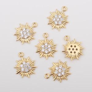 May include: Six gold-toned starburst charms with clear crystal accents. Each charm has a loop for attaching to a necklace or bracelet.