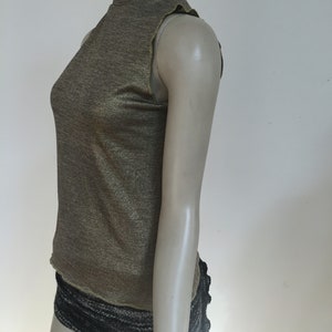May include: A sleeveless gold metallic turtleneck top with a mock neck.