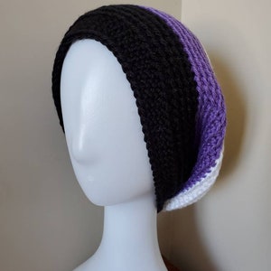 Peut inclure: Un bonnet crocheté à la main aux couleurs du drapeau de la fierté asexuelle : noir, gris, violet et blanc. Le chapeau est présenté sur une tête de mannequin blanche. Le bonnet est un accessoire doux et chaud.