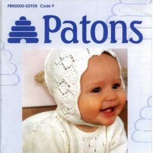 Może przedstawiać: Biały zestaw dzianinowy dla niemowląt składający się z czapki i sukienki z delikatnym wzorem koronkowym. Zestaw wykonany jest z przędzy Patons Fairytale DK & 4PLY i zawiera 12 wzorów dla niemowląt do 2 lat.