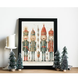 May include: A framed print depicting four nutcracker soldiers in a whimsical style. The nutcrackers are dressed in red, blue, and green uniforms with gold accents. The print is set against a white background with a snowy effect.