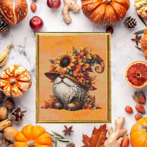 May include: A framed artwork featuring a gnome wearing a hat adorned with sunflowers and autumn leaves. The gnome has a long white beard. The artwork is surrounded by pumpkins, gourds, apples, and fall foliage, creating a seasonal theme.