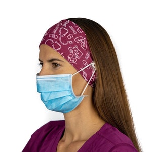 May include: A burgundy headband with a white print of medical symbols and the text "HEALTHCARE HEROES". The headband has a button on each side to hold a face mask.