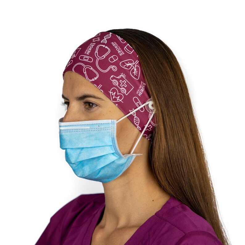 May include: A burgundy headband with a white print of medical symbols and the text "HEALTHCARE HEROES". The headband has a button on each side to hold a face mask.