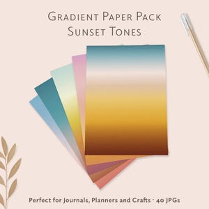 Op de afbeelding: Een verzameling gradiëntpapier in zonsondergangtinten, uitgewaaierd om de kleurvariaties te laten zien. Het papierpakket bevat tinten blauw, roze, geel, oranje en bruin. De tekst op de afbeelding luidt "Gradient Paper Pack Sunset Tones".
