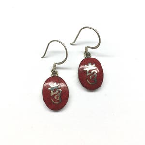 May include: A pair of silver earrings with red enamel and silver lettering. The lettering is in Chinese characters.