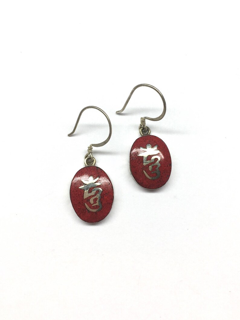 May include: A pair of silver earrings with red enamel and silver lettering. The lettering is in Chinese characters.