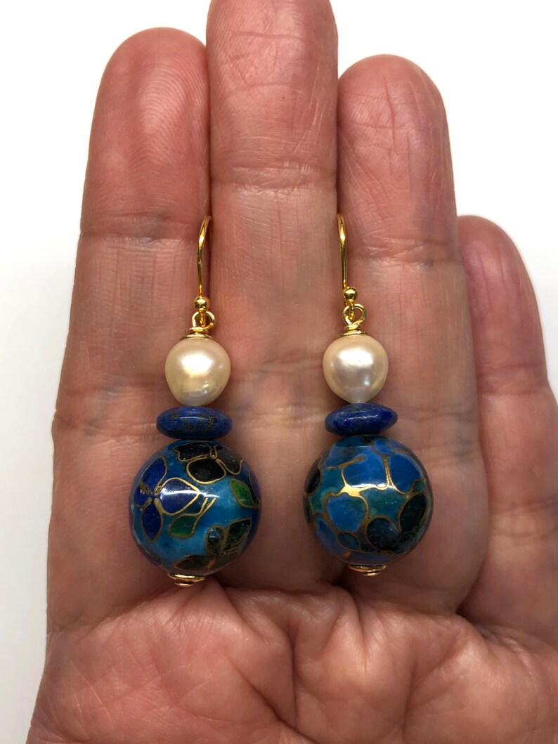 May include: Gold earrings with a blue and white cloisonn&eacute; bead and a white pearl bead.