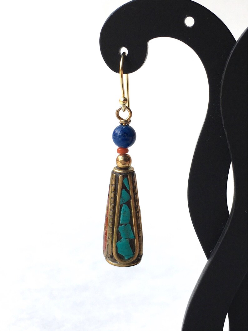 May include: Gold dangle earrings with a turquoise and red stone teardrop pendant and a blue bead.