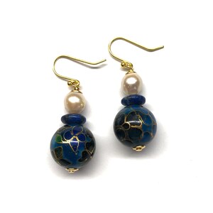 May include: A pair of gold dangle earrings with blue and gold enamel beads, white pearls, and blue lapis lazuli beads.
