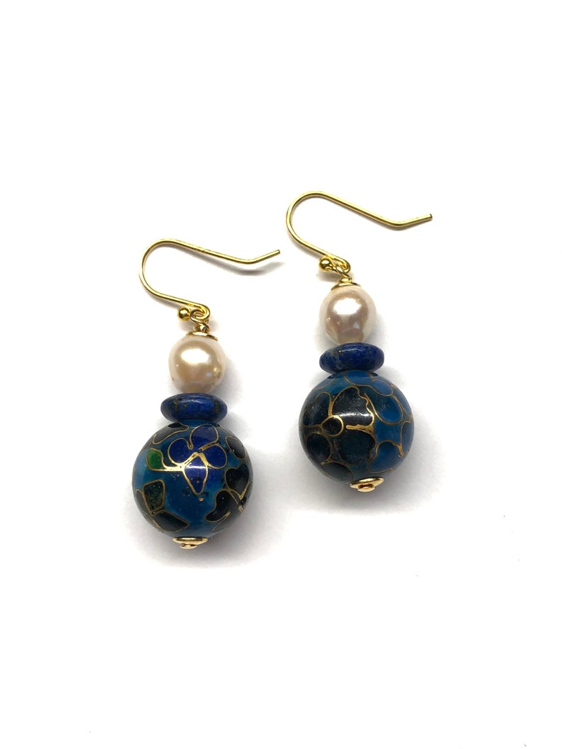 May include: A pair of gold dangle earrings with blue and gold enamel beads, white pearls, and blue lapis lazuli beads.