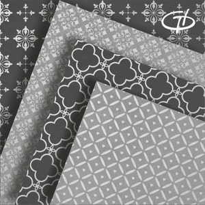 May include: An assortment of patterned paper sheets in shades of gray and white. The designs include floral, quatrefoil, and geometric patterns. The paper sheets are arranged in a layered, angled composition, showcasing the variety of designs.