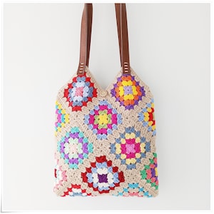 May include: A crocheted tote bag with colorful granny squares and brown leather straps.