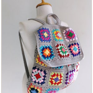 Pu&ograve; includere: Uno zaino in crochet grigio con quadrati di granny colorati. Lo zaino ha una chiusura a coulisse e spalline regolabili.
