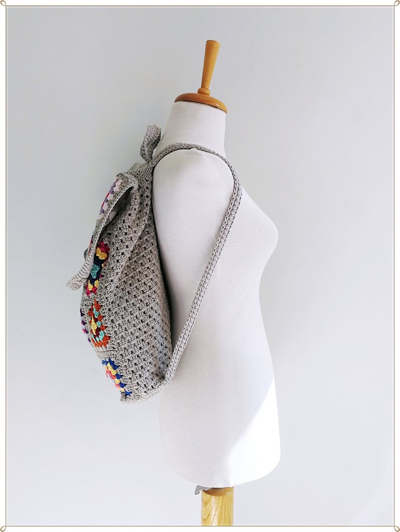 Pu&ograve; includere: Uno zaino in crochet grigio con disegni quadrati colorati. Lo zaino ha spalline regolabili e una chiusura a coulisse.