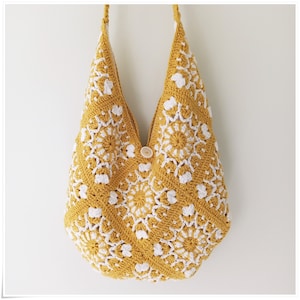 Puede incluir: Un bolso tote de crochet con un patr&oacute;n geom&eacute;trico amarillo y blanco. El bolso tiene un cierre de bot&oacute;n &uacute;nico.