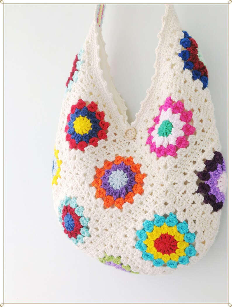 May include: A white crocheted tote bag with colorful granny squares. The squares feature a variety of colors, including red, blue, yellow, green, and purple.
