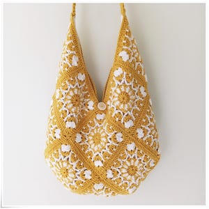 May include: A crocheted tote bag with a yellow and white geometric pattern. The bag has a single button closure.