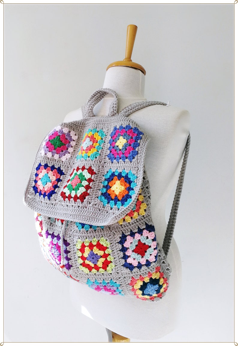 Pu&ograve; includere: Uno zaino in crochet grigio con toppe di granny square colorate. Lo zaino ha spalline regolabili e una chiusura con coulisse.