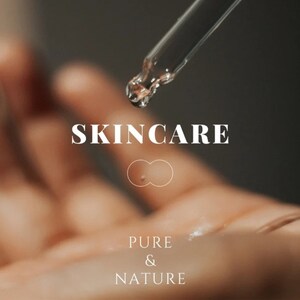 Pu&ograve; includere: Primo piano di una mano con una goccia di liquido trasparente che cade da un contagocce. Il testo "SKINCARE" &egrave; in lettere bianche su uno sfondo sfocato. Sotto il testo c'&egrave; un simbolo di infinito bianco e le parole "PURE & NATURE".