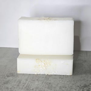 May include: Two white rectangular bars of soap with a subtle shimmer. The soap is stacked on top of each other.