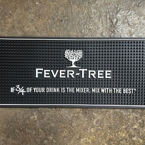 May include: Black bar mat with a white tree logo and the text "FEVER-TREE" and "IF 3/4 OF YOUR DRINK IS THE MIXER, MIX WITH THE BEST™".