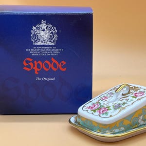 May include: A white porcelain cheese dish with a floral design and gold trim. The dish is in a box with the Spode logo and the text "The Original".