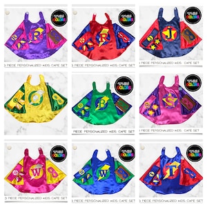 May include: A set of five superhero capes for kids. The capes are made of satin and come in a variety of colors, including red, blue, green, yellow, and pink. Each cape has a different letter on the front, and the set includes a matching mask and wrist cuffs.