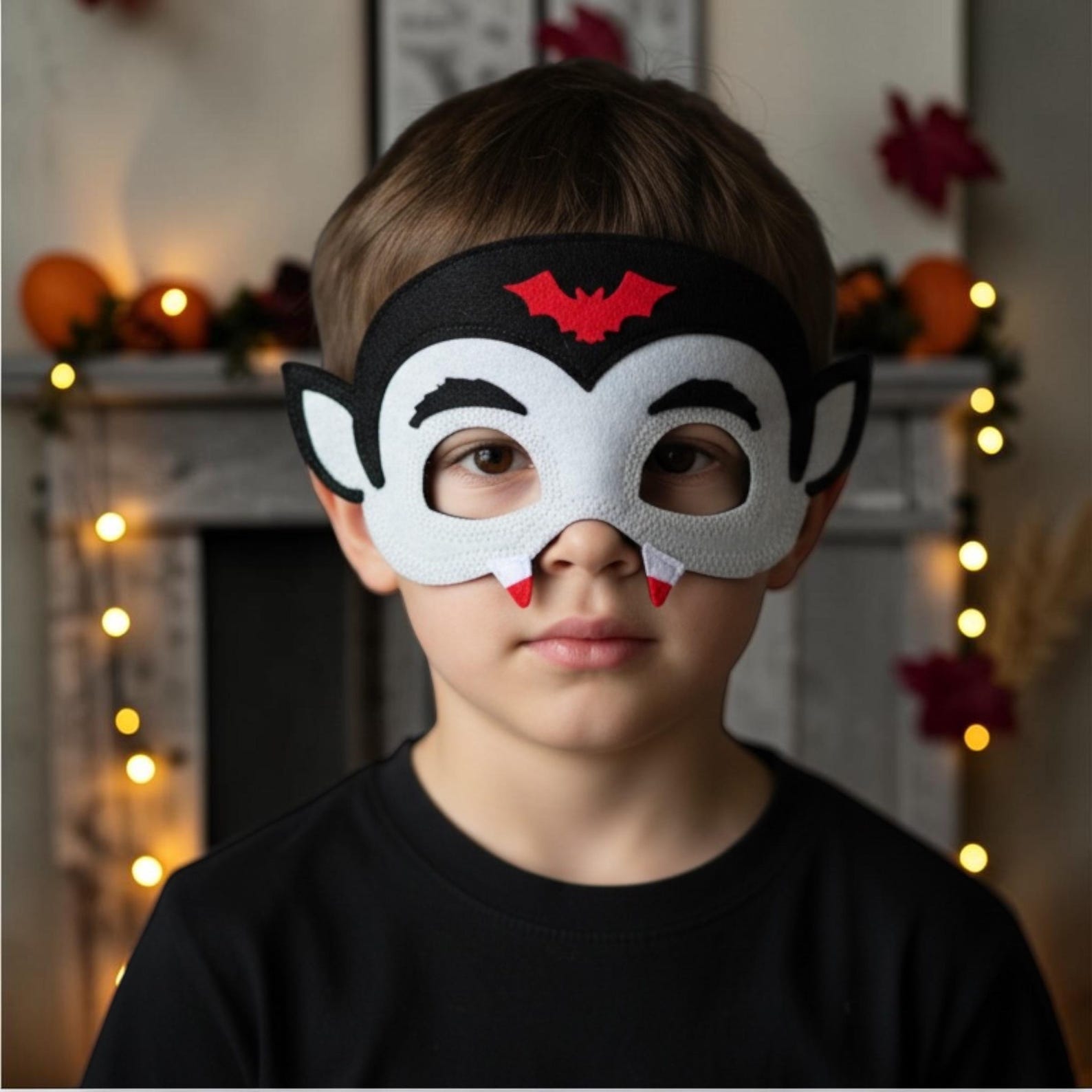 White vampire felt mask with black hair and red accents.