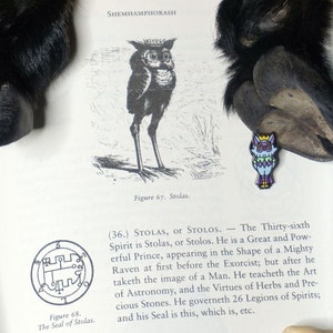 May include: A black and white illustration of an owl with the text "Figure 67. Stolas." below it. The text "(36.) STOLAS, or STOLOS. - The Thirty-sixth Spirit is Stolas, or Stolos. He is a Great and Powerful Prince, appearing in the Shape of a Mighty Raven at first before the Exorcist; but after he taketh the image of a Man. He teacheth the Art of Astronomy, and the Virtues of Herbs and Precious Stones. He governeth 26 Legions of Spirits; and his Seal is this, which is, etc." is also included.