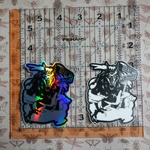 May include: Two stickers of a wolf holding a sign that says "Bray Wolf River Trail". One sticker is a holographic silver color and the other is black and white.