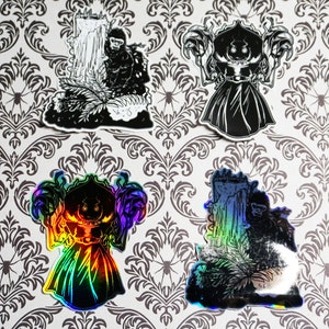 May include: Four black and white stickers with a spooky theme. The stickers feature a ghost, a monster, and two figures standing in front of a waterfall. The stickers are printed on a white background.