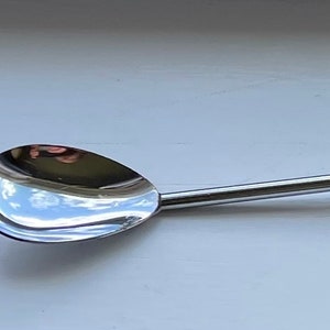 May include: A silver egg spoon with a long handle and a rounded bowl. The spoon has a polished finish and is designed for scooping eggs.