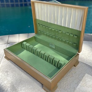 May include: A wooden cutlery box with a green velvet interior and a label that reads "The Gorham Co."