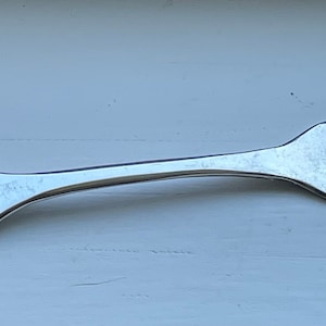 Peut inclure: Fourchette en argent avec un manche orné d'un motif en relief de trois ours. La fourchette a quatre dents.