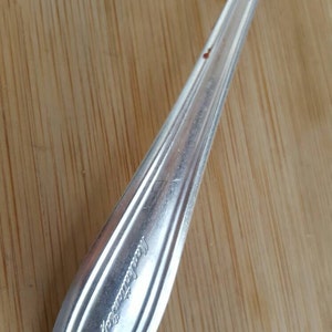 May include: A silver spoon with the word "International" engraved on the handle.