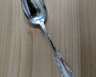 May include: A silver spoon with an ornate, floral design on the handle.