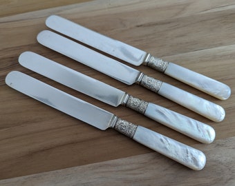 Può includere: Quattro coltelli d'argento con manici in madreperla. I manici sono bianchi con un motivo a spirale.