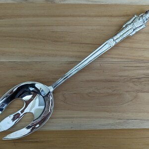 Peut inclure: Une fourchette à salade en argent avec un manche orné d'un chevalier debout.