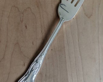 Peut inclure: Une fourchette en argent avec un manche orné. La fourchette a quatre dents et un motif décoratif sur le manche.