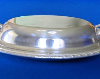 以下が含まれることがあります： 蓋と2つの取っ手がついた銀製の楕円形のサービングディッシュ。ディッシュの縁には装飾的な縁取りがあります。