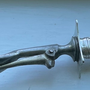 May include: A silver serving fork with a decorative handle. The handle has an ornate design with a floral motif.