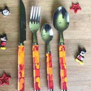 May include: A set of four stainless steel Mickey Mouse themed cutlery pieces. The knife, fork, and two spoons have orange and red handles with a Mickey Mouse pattern.