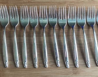 May include: A set of twelve silver forks with a floral design on the handle.